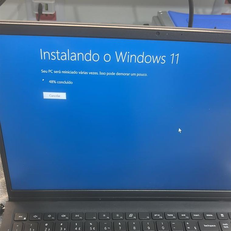 Notebook na bancada com a tela mostrando a instalação do Windows 11 em andamento