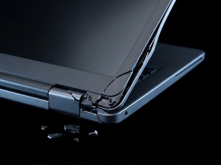 Dobradiça de notebook arrancada, com a carcaça trincada e fragmentos de plástico soltos